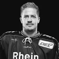 Un homme portant un maillot de hockey sur glace noir avec le logo owayo sur la poitrine et l'inscription 'Rhein' sur le devant.