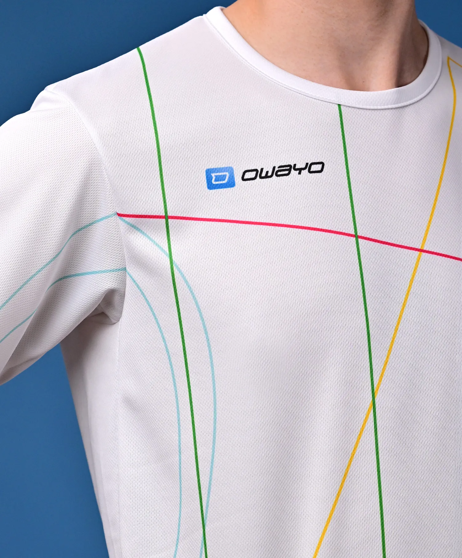 Un t-shirt sportif blanc avec des lignes diagonales colorées en vert, bleu, rose et jaune, présenté sur un fond neutre.