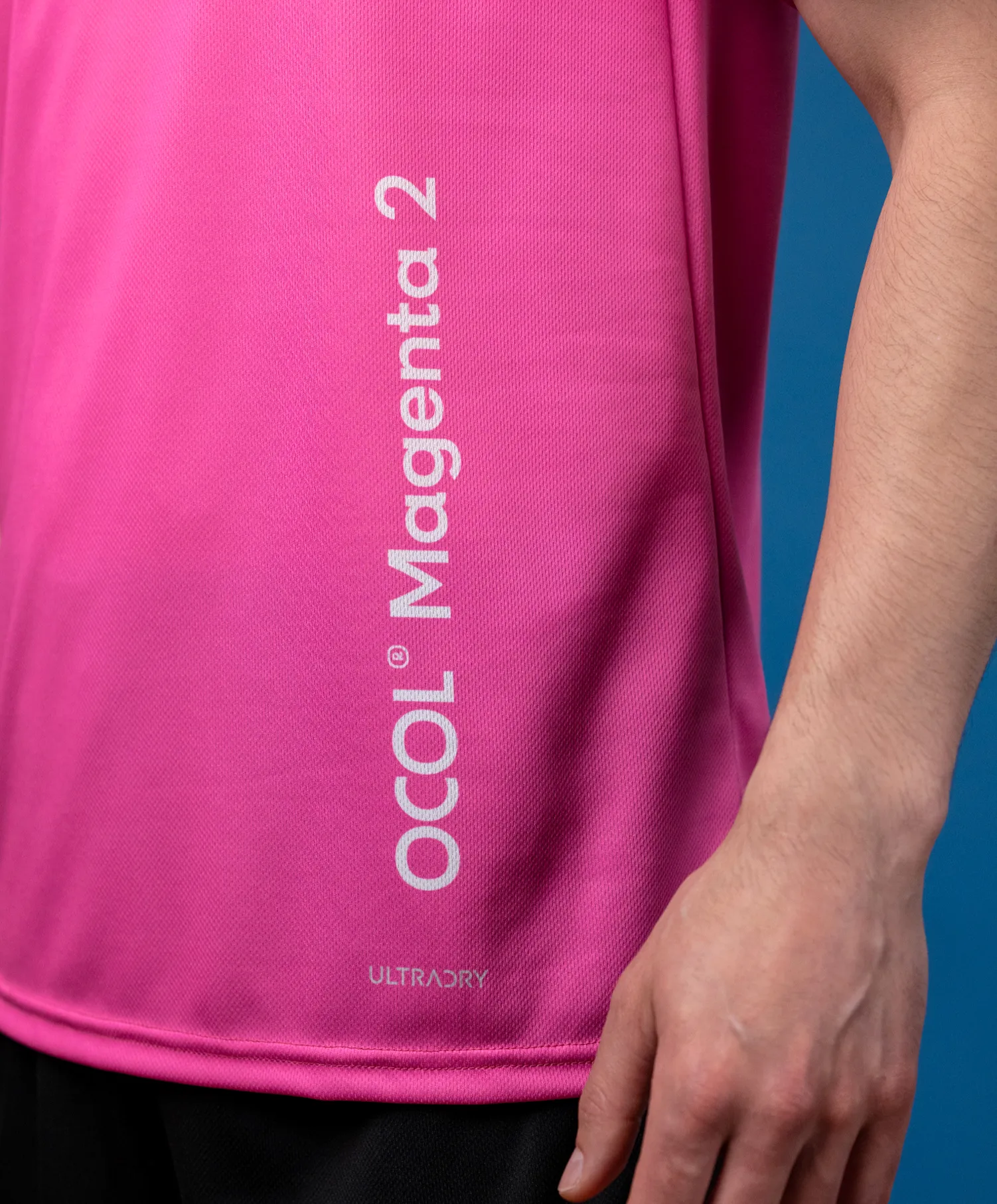 Un haut de sport rose avec un logo et le texte 'Magenta 2'.